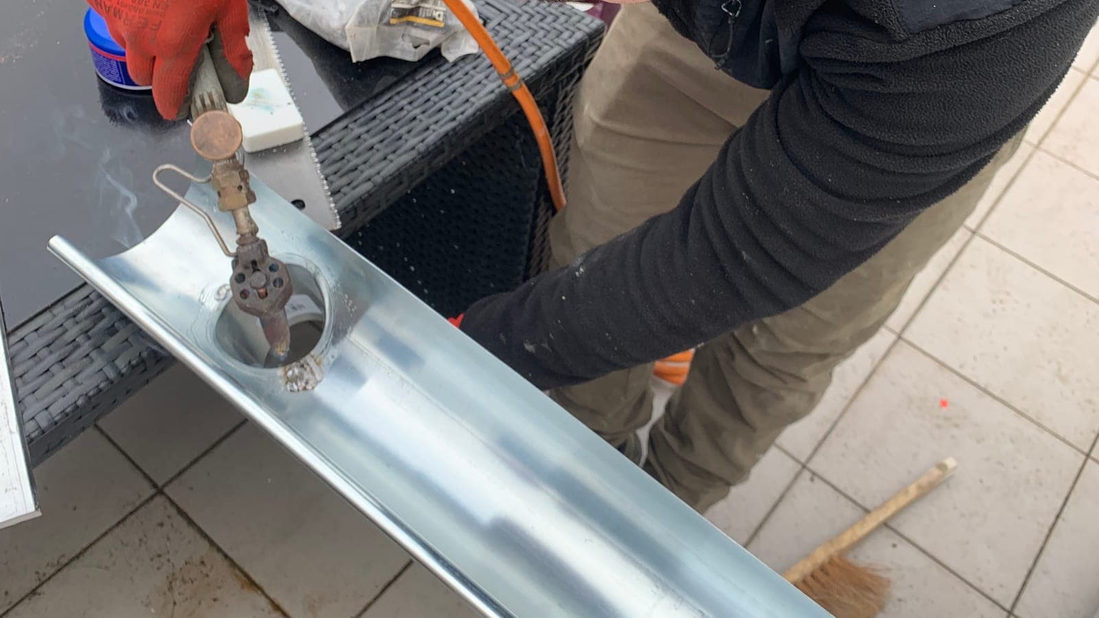 Gouttière demi-ronde en zinc soudée au fer, gants de travail
